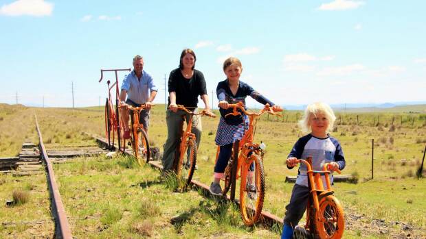 Will Jardine and his wife Caroline and two children Izzy, 6, and Jack, 3, pose on bikes on the old railway line between Cooma and Nimmitabel. Photo: Dave Moore

