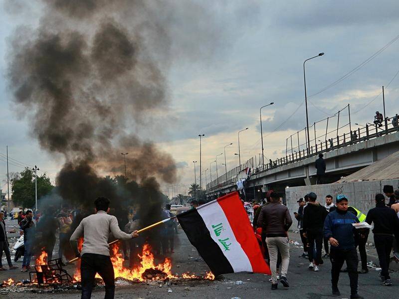 Protesters started fires to close a key highway during clashes with security forces in Baghdad