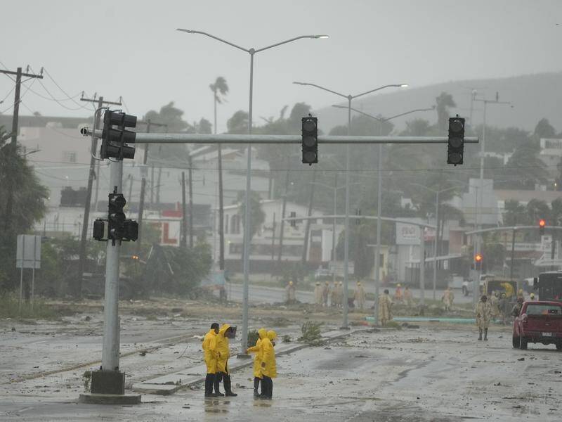 Rescue teams remove mud from a avenue flooded by the rains of Hurricane Norma in San Jose del Cabo. (AP PHOTO)