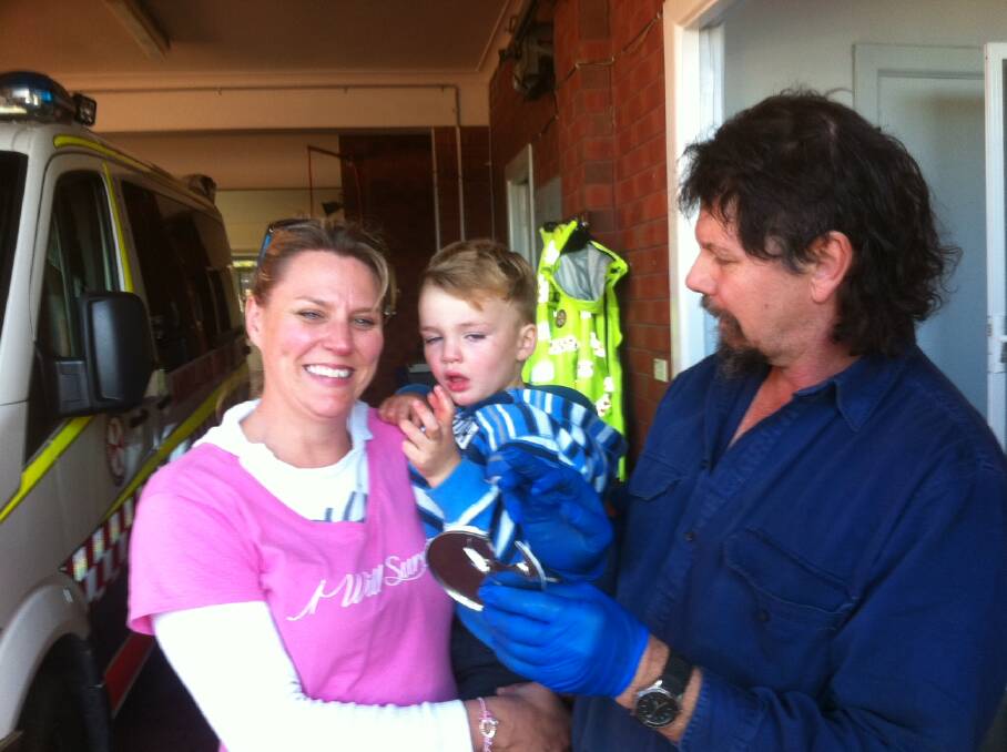 FINGER RESCUE: Pictured after cutting off the can, without further damage to the finger, is Narooma Rescue Squad member Jeff Garrad with Tex and his mum.   