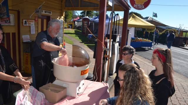 FLOSSY FOLK: Tilba post master Ken Jamieson and assistant Julie Andreassen from Bates Store operate their fairy floss machine at the Tilba Festival on Easter Saturday.