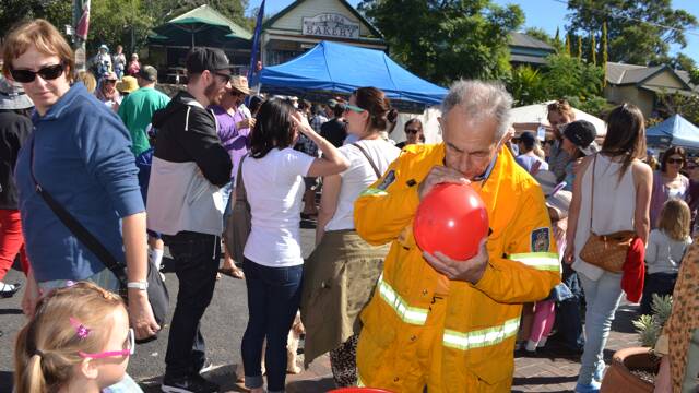 
BALLOON MAN: Tilba RFS brigade member Harry Ghazikian blows up another balloon at the Tilba Festival on Easter Saturday to raise funds for the firefighters.
