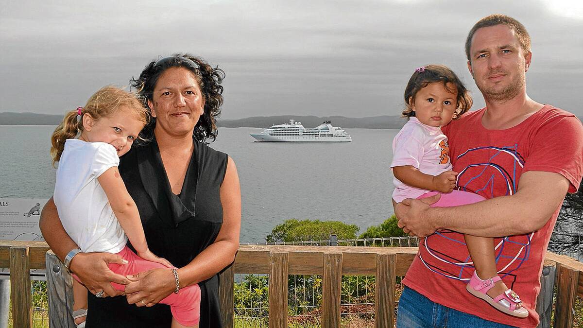 LOVE BOAT: Eden residents Clair Mudaliar and Christian Oyrer and their daughters Vivienne and Sophia with the cruise ship Seabourn Sojourn on Twofold Bay on Monday.