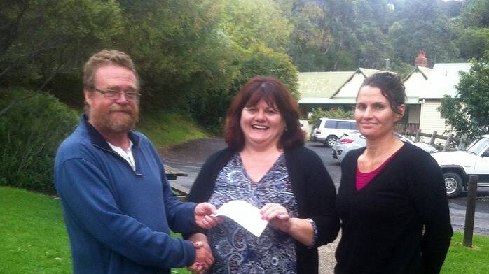 FESTIVAL DONATION: Chrissy Montague and Erica Dibden handing over cheque for $2000 from Tilba Festival Committee to Narooma Men’s Shed representative Phill Stokes.  