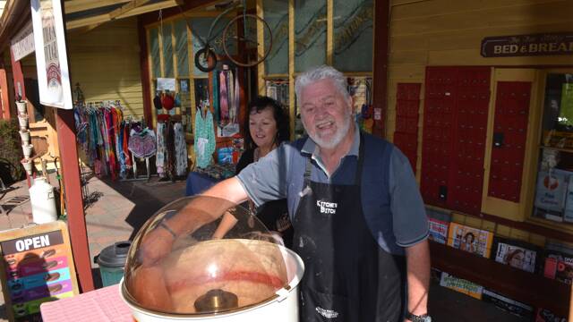 FLOSSY FOLK: Tilba post master Ken Jamieson and assistant Julie Andreassen from Bates Store operate their fairy floss machine at the Tilba Festival on Easter Saturday.
