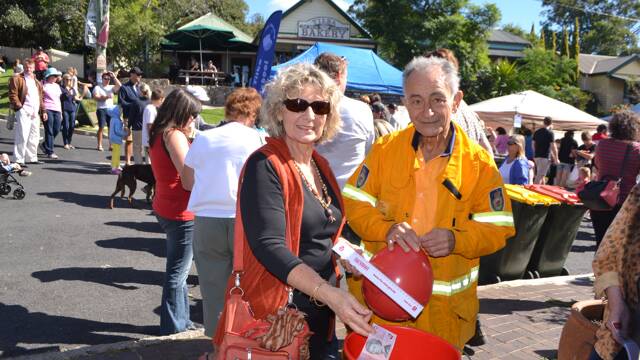 BALLOON MAN: Nelleke Gorton of Tanj with Tilba RFS brigade member Harry Ghazikian blowing up another balloon at the Tilba Festival on Easter Saturday to raise funds for the firefighters.