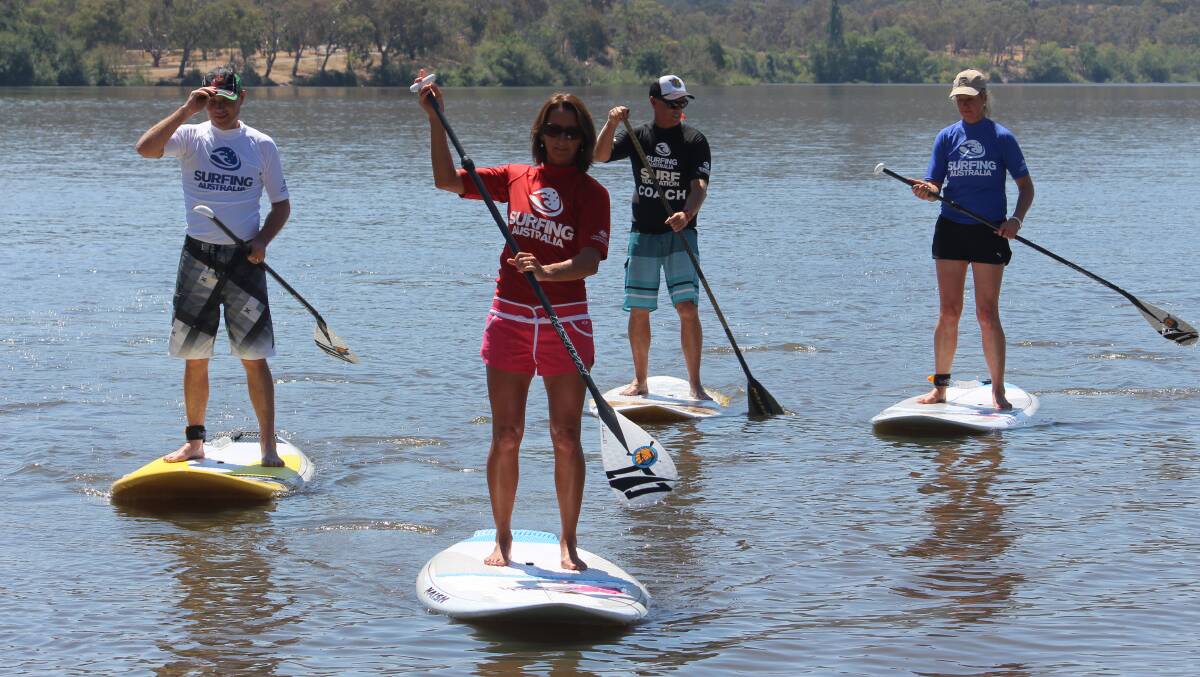 SUP MASTER: MP Andrew Laming, champion Layne Beachley and Senator Bridgette McKenzie under the watchful eye of coach Andrew “Macca” McCaughtrie (third from right). 