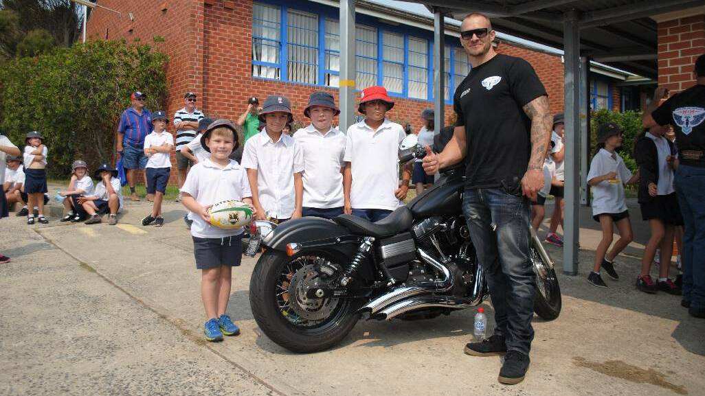 FOOTY LEGEND: Matt Cooper was a massive hit among the primary school students and is pictured here showing off his Harley to Harry McLaren, Jack Bennett, Hayden Rapley and AJ Foster.