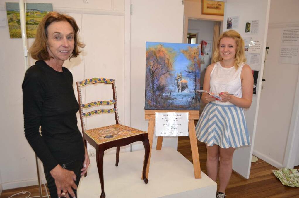 MACS RAFFLE: MACS Easter Exhibition committee member Anne Pyle and visiting art enthusiast Lucy Hudson from Canberra with the two items being raffled off to raise money.