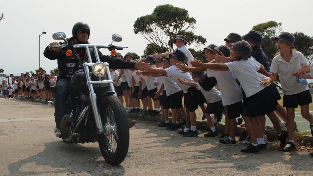 THUNDEROUS CHARGE: Former St George Illawarra Dragons player Matt Cooper gave the kids what they wanted as he roared out the school driveway on his Harley Davidson.