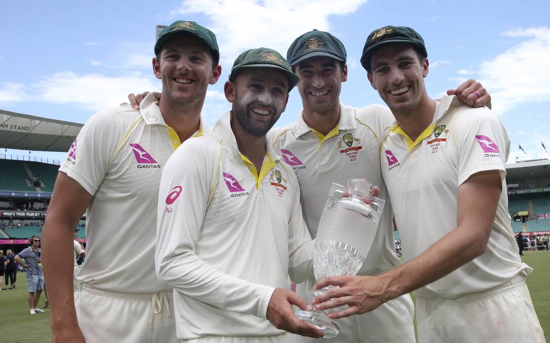 Australian bowlers Josh Hazlewood, left, Nathan Lyon, Mitchell Starc, second right, and Pat Cummins, right, hold the Ashes trophy as they celebrate at the end the last day of their Ashes cricket test match against England in Sydney, Monday, Jan. 8, 2018. Australia win the series 4-0. (AP Photo/Rick Rycroft)