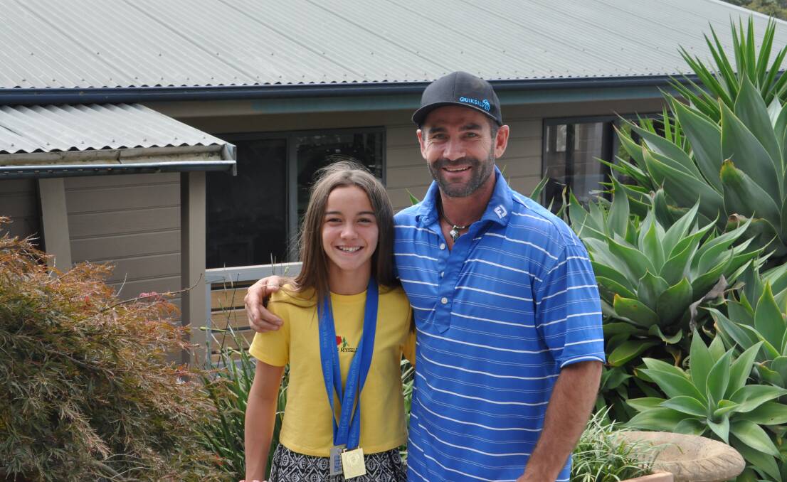 Mystery Bennett with her proud dad Justin. Bennett won a gold and silver medal at the recent NSW State Surf Lifesaving Championships in Swansea.