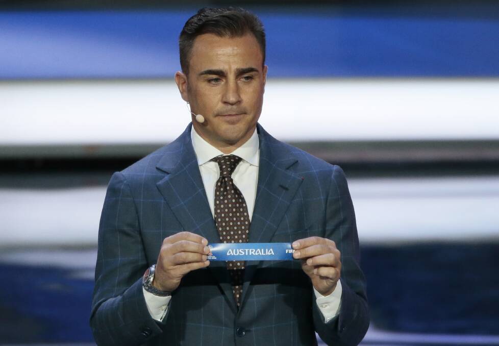 Former Italian soccer international Fabio Cannavaro holds up the team name of Australia during the 2018 soccer World Cup draw in the Kremlin in Moscow, Friday, Dec. 1, 2017. (AP Photo/Ivan Sekretarev)