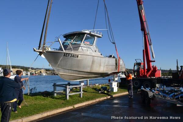 RECOVERY: The fishing boat owners together with crane driver Darren Clark and rigger Michael Brown recover the boat out of the Bermagui harbour on Monday morning.