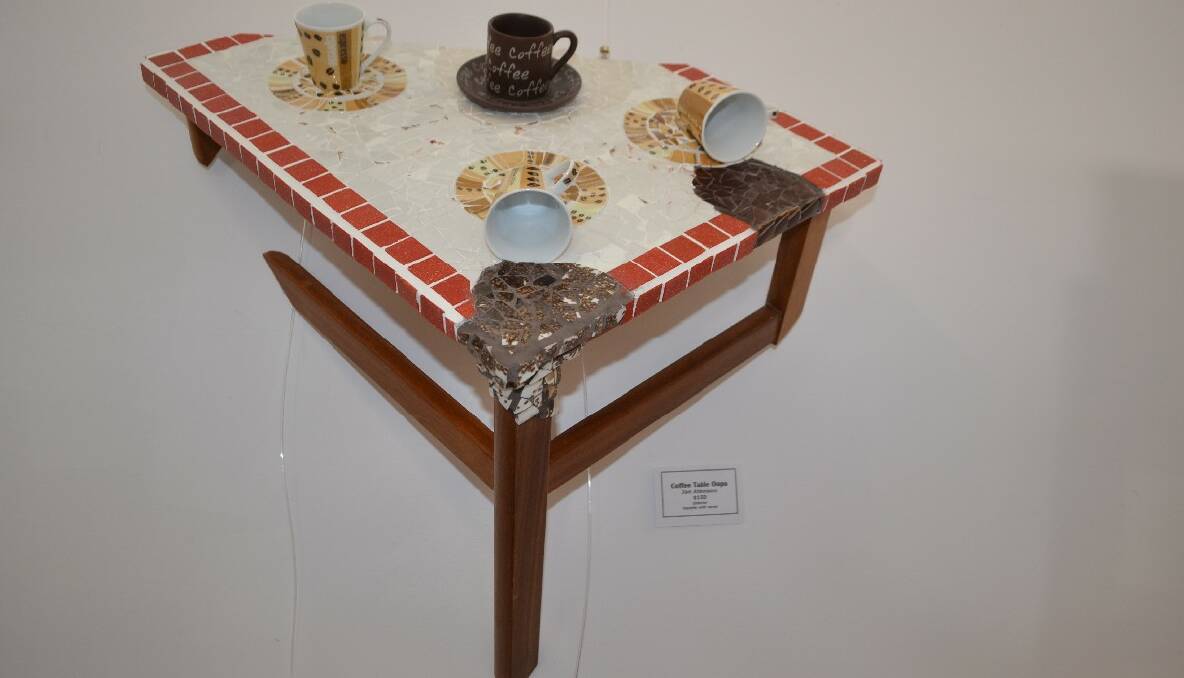 AMAZING TABLE: “Coffee Table Oops” by Jan Atkinson merges with the wall with a mosaic of spilled coffee. 