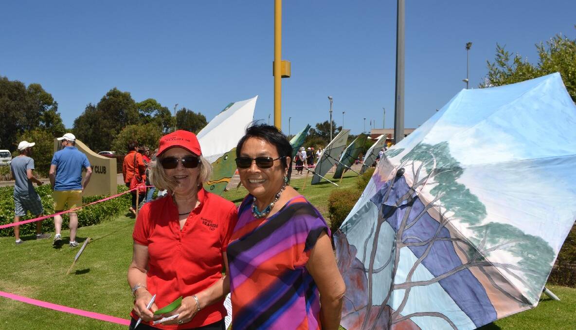 MOUNTAIN SCENE: Bermagui Seaside Fair committee member Denise Page and local artist Anh Thu Stuart, whose umbrella reminded Catriona’s son of his home back in Victoria. 