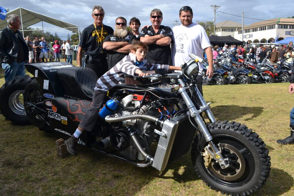 DRAG DRAW: Riding the big Mongrel Racing V8 dirt drag bike at the CRABs bike show is young Rhama Agius of Bermagui with chapter founder Rob Grimstone, bike handler Steve Henness of Narooma, dad Jarrad Agius and crew members Chris Woods and Mark from Injection Perfection pictured behind. 