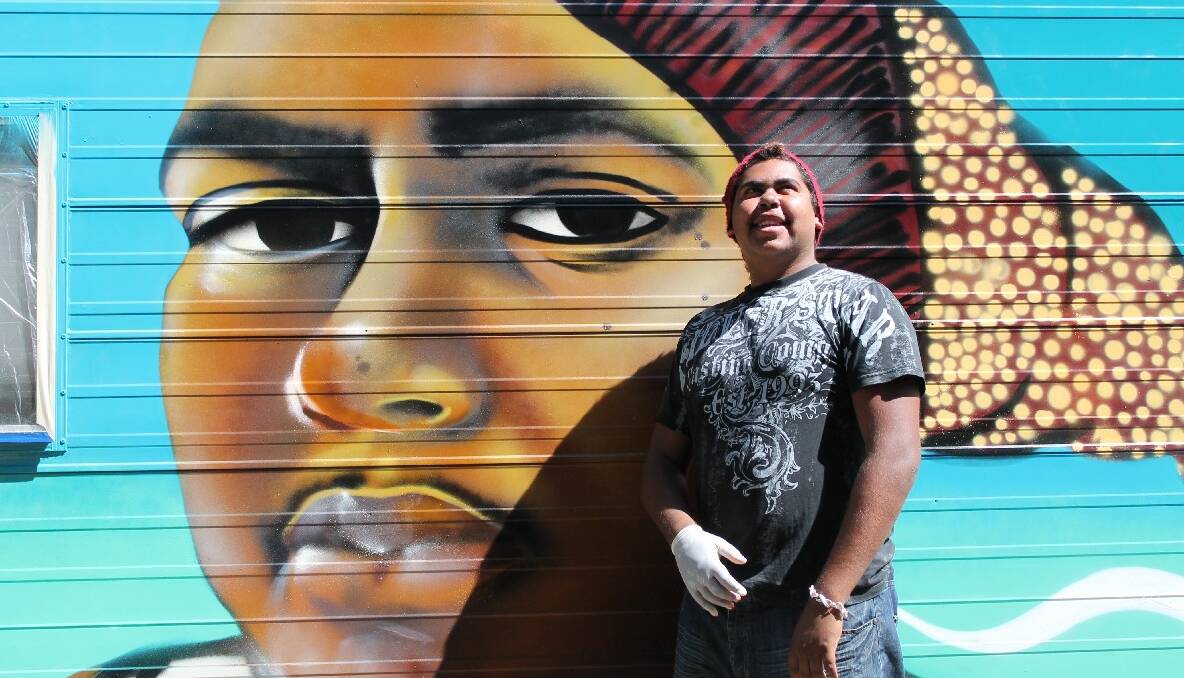 STREET ART: Local Koori youth Warren Foster Jnr with his likeness painted in the side of “Patty” the medical outreach van. 