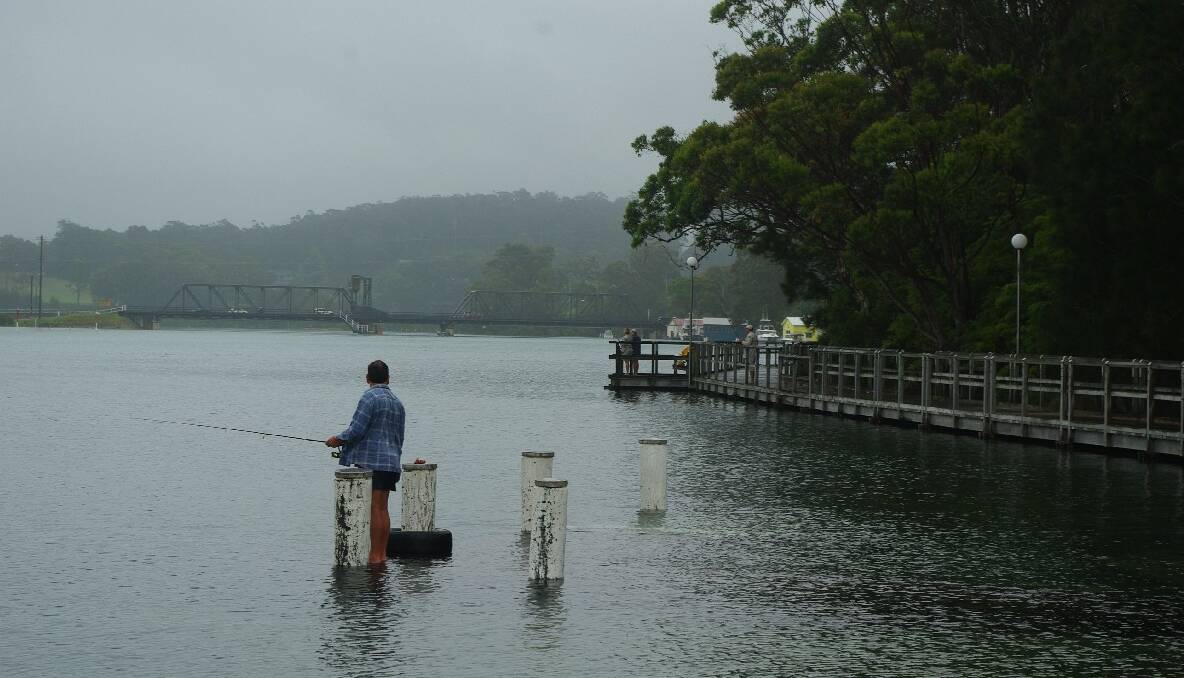 APEX PARK: A lone fisherman fishes the high tide from the submerged pontoon at Apex Park. 