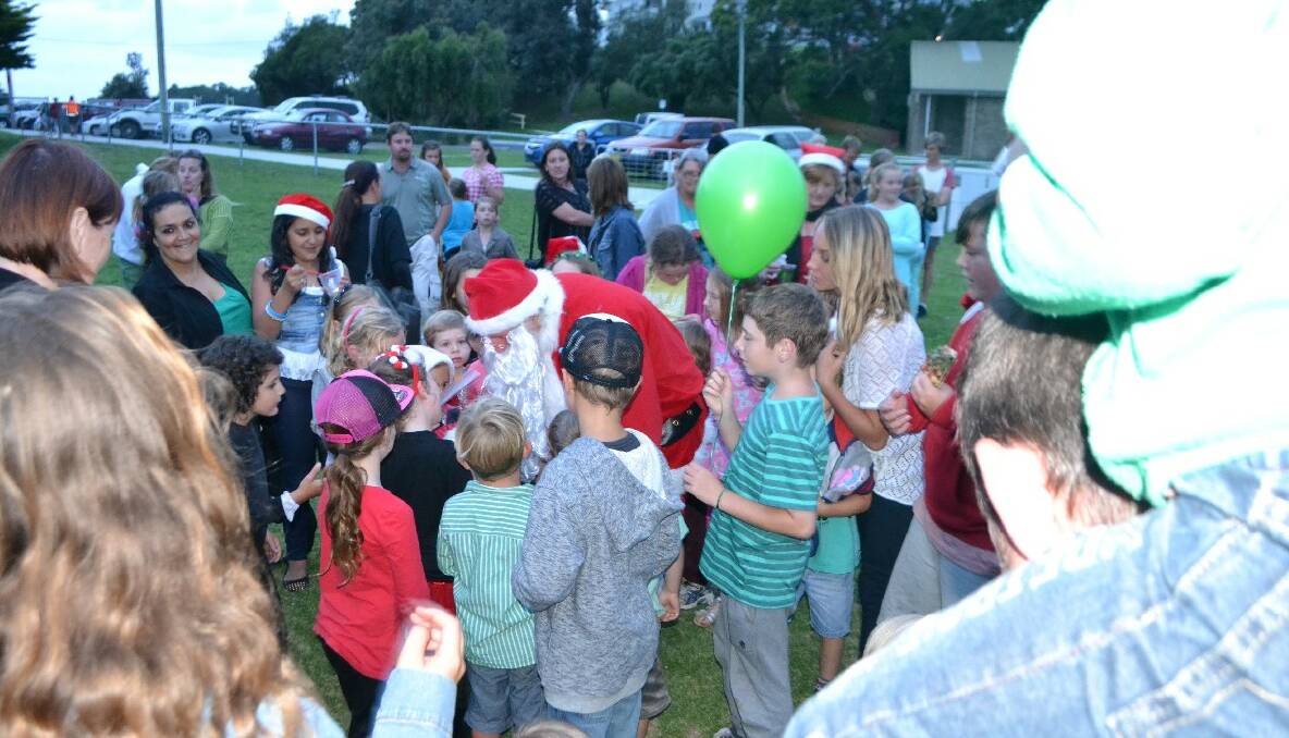 SANTA ARRIVES: Great excitement when Santa arrived at the Narooma Christmas carols on the back of a RFS fire engine. 