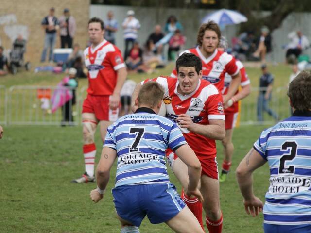DEVILS CHARGE: Narooma Rugby League Devils captain and coach Todd Wright shows determination as he runs with the ball in Sunday’s grand final game against the Moruya Sharks.