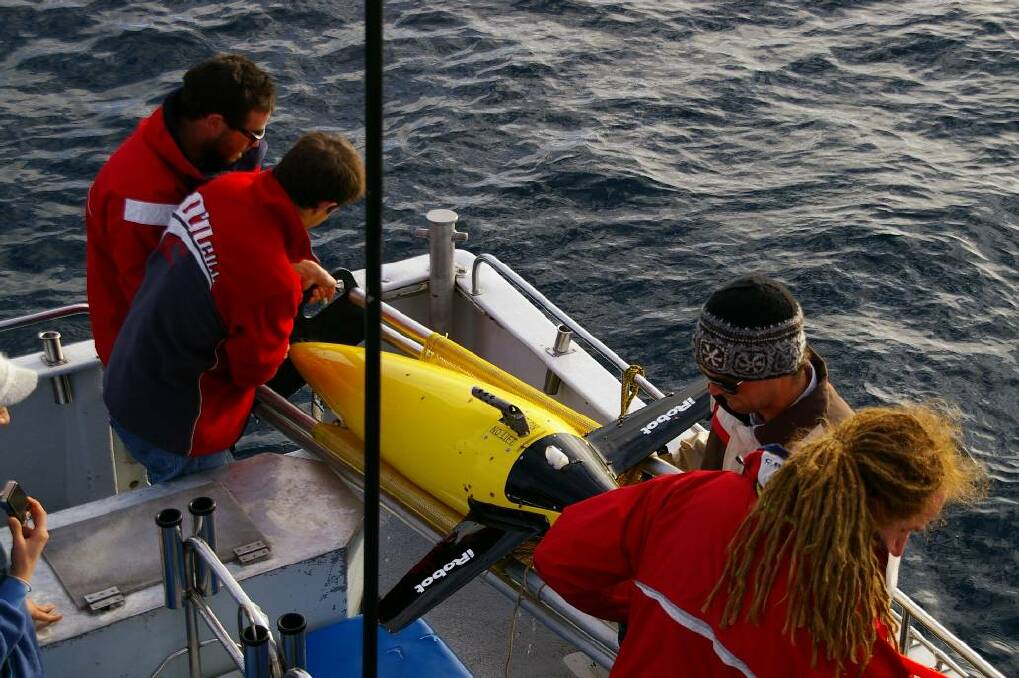GLIDER RECOVERY: Nick Ingersole, Ludovic Grosjean, deckhand Johnno Bettini and Dennis Stanley recover the glider about 33km out from Narooma on Tuesday. 